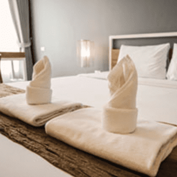 Two towels folded on the end of a bed
